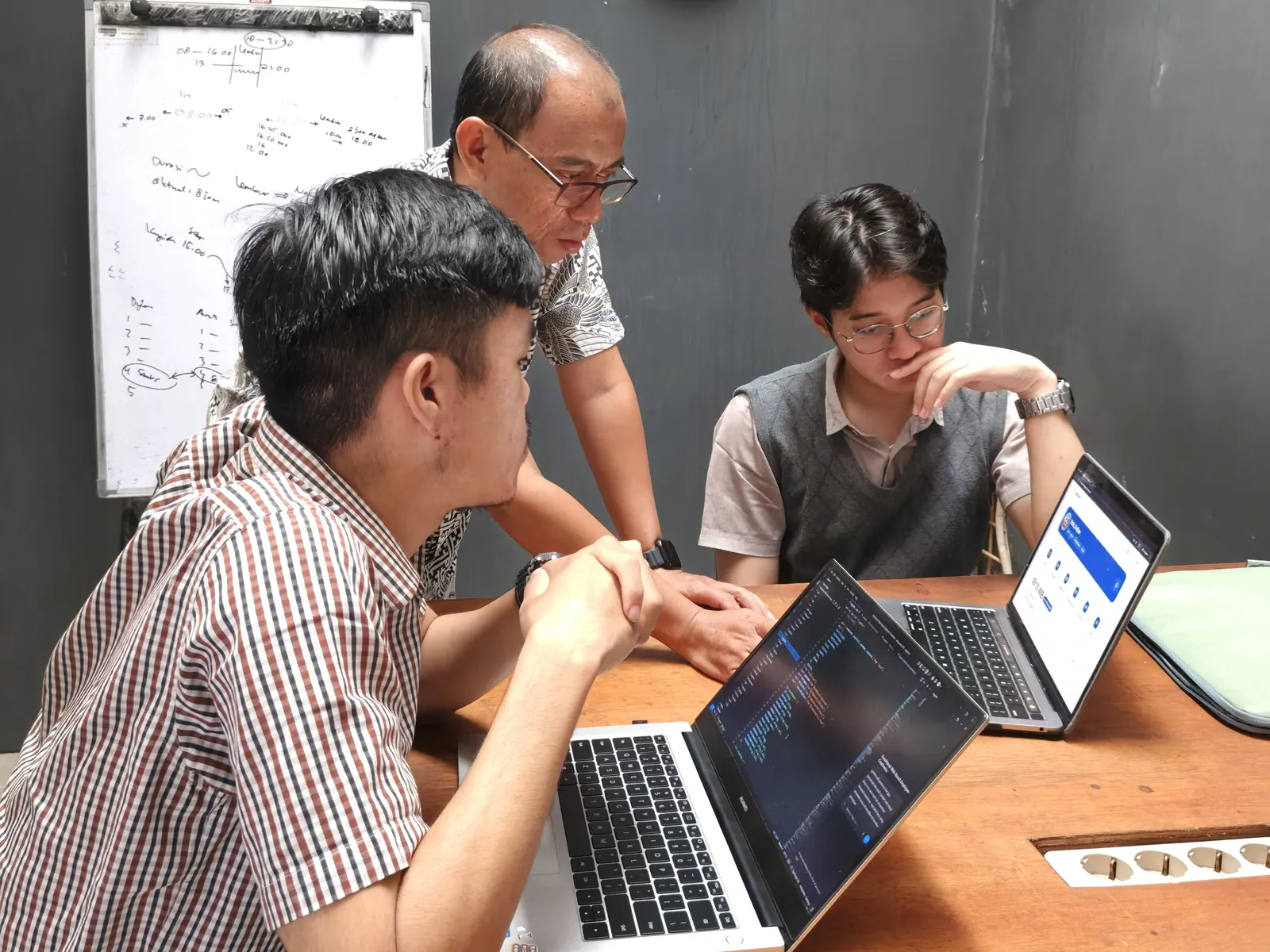 Dua peserta dan pembimbing berdiskusi di depan laptop