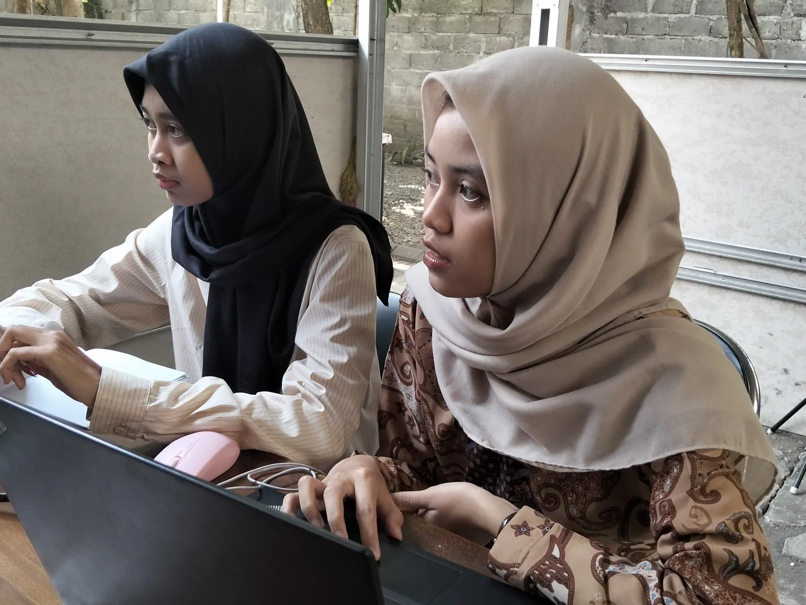 Dua peserta menyimak arahan dengan saksama di meja kerja